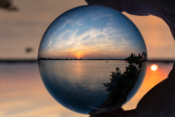 Lens ball shot of a fisherman floating on lake Zoetermeerse Plas during a beautiful sunset with a...