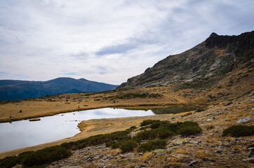 Fototapeta na wymiar Lake on a rocky mountain landscape on Guadarrama mountain range, Peñalara, Madrid, Spain