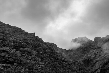 Black and white mountain peak under dark clouds