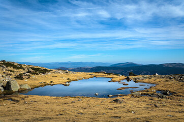 Small lake on a rocky mountain landscape on Guadarrama mountain range, Peñalara, Madrid, Spain