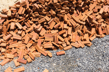 Red bricks piled up along the side of the road.