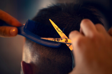 Close up of hands holding scissors at barber shop.