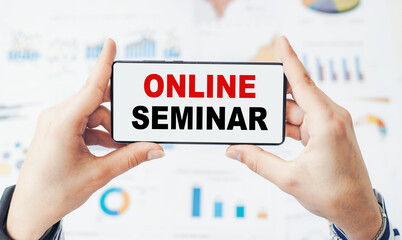 Online seminar - text on a smartphone in the hands of a woman on the background of financial charts