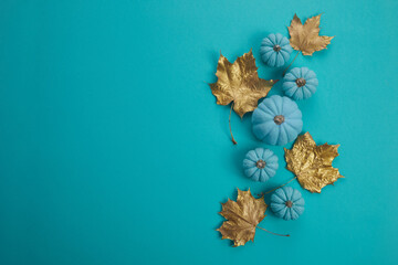 Flat lay autumn composition. Frame made of aqua colour pumpkins and dried golden leaves. Harvest thanksgiving halloween