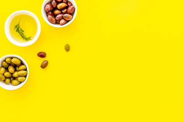 Olive oil in bowl near oilves from above copy space