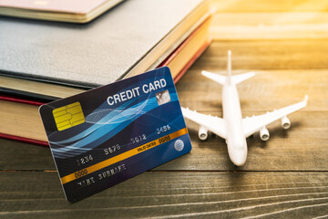 Credit card and airplane model on wooden table