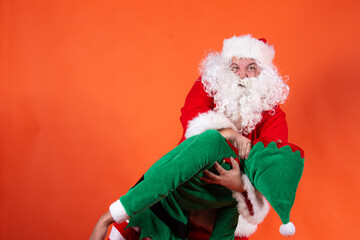 Couple. Funny santa claus. Orange background.