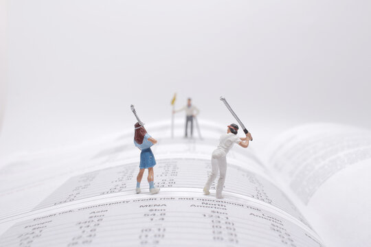 mini figure play the golf on the open book