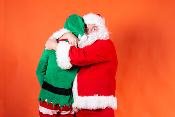 Couple. Funny santa claus. Orange background.
