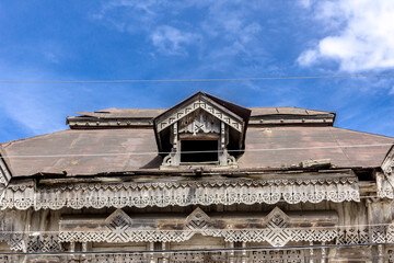 Fototapeta premium Details of the old manor, decorated with carvings. Roof, skylight and wooden frieze. Nineteenth century architecture. Town Borovsk in Russia.