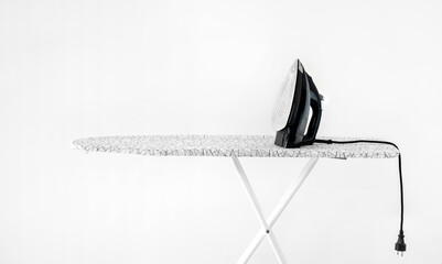 iron on ironing board against white wall background. High quality photoiron on ironing board...