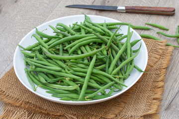 tas d'haricots verts cru sur une table en bois