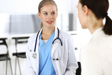 Fototapeta premium Woman - doctor consults her female patient in clinic. Medicine concept
