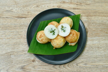 Thai sweetmeat baking coconut pudding topping slice spring onion in banana leaf on dish