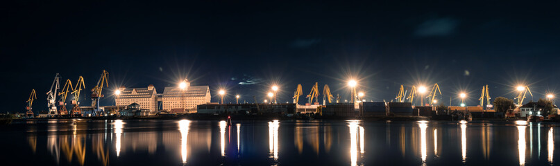 panorama of night port on the river with a cranes