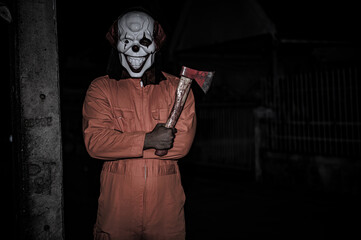 Asian handsome man wear clown mask with weapon at the night scene,Halloween festival concept,Horror...