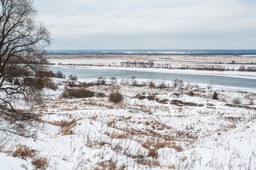 Winter monochrome landscape: white snow field and river