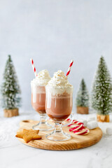 Hot chocolate or coffee with whipped cream  served with a candy cane, marshmallows, and gingerbread star