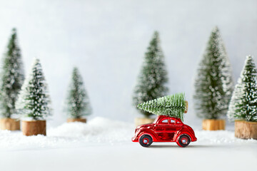 Cute winter holidays concept with retro car transporting Christmas tree