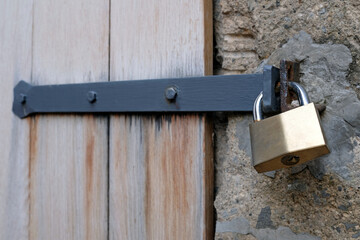 Metal padlock at an old wooden gate