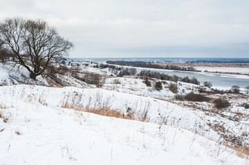 Winter monochrome landscape: white snow field and river