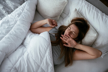 Young beautiful woman enjoying in morning.. Girl lying on bed..