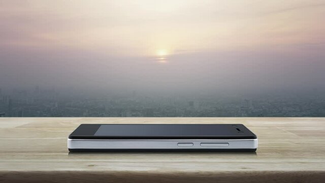 Play button flat icon on modern smart mobile phone screen on wooden table over city tower and skyscraper at sunset, vintage style, Business music online concept
