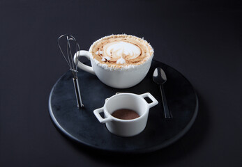 Coconut Latte coffee with cookie on black plate