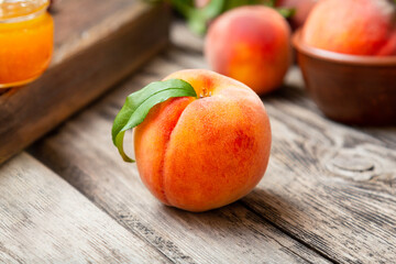 Peach fruit with leaf. Ripe juicy orange peach fruit of peach tree on wooden cutting rustic board. Peach harvest closeup in dark key.