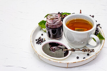 Elderberry jam from ripe berries and hot tea