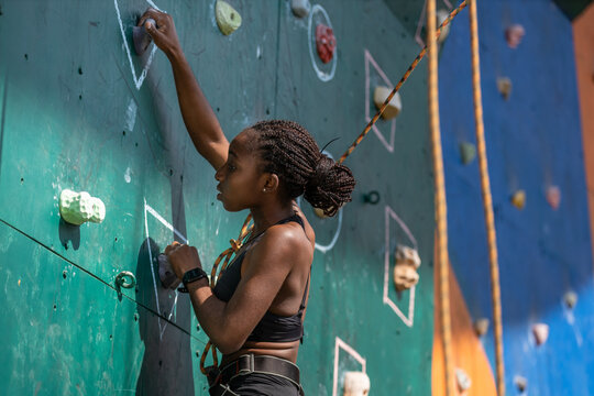 Young black woman climbing on climbing wall