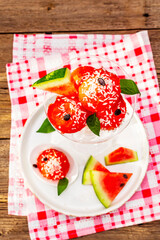 Sweet watermelon ice cream with coconut flakes and fresh basil leaves