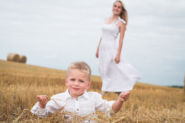 Beautiful mother and son are photographed in a wheat field