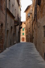 Fototapeta na wymiar Medieval town Pienza in Val d'Orcia, Tuscany, Italy, narrow alley, old houses on both sides