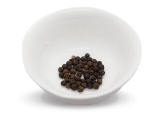 Black pepper, herbs, spices in a white bowl in top view.