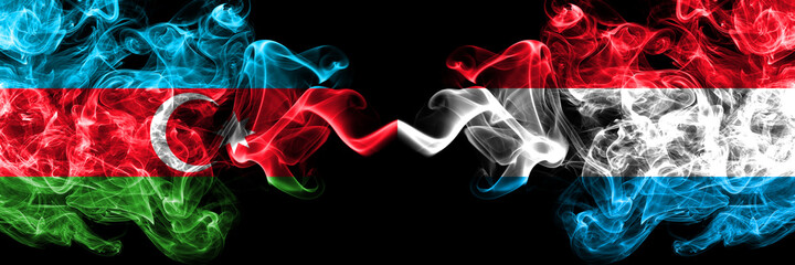 Azerbaijan, Azerbaijani vs Luxembourg smoky mystic flags placed side by side. Thick colored silky abstract smoke flags