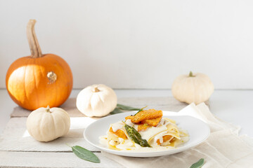 Lasagne with pumpkin on plate, white background