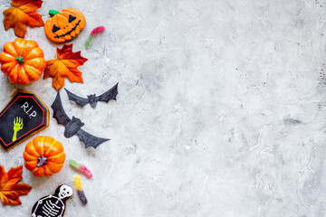 Halloween decoration concept with pumpkins, cookies and autumn leaves, top view