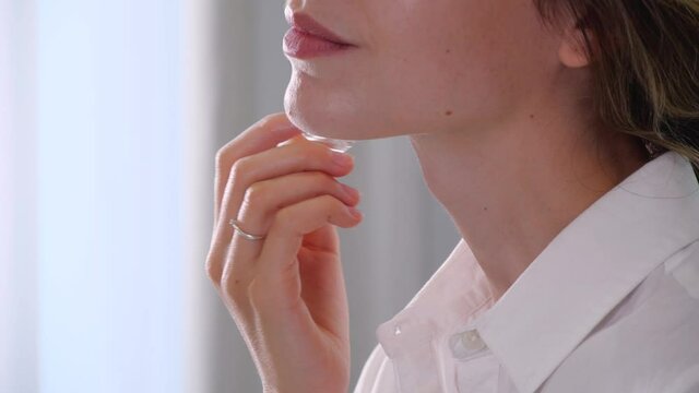 Woman applying roller perfume at home, closeup
