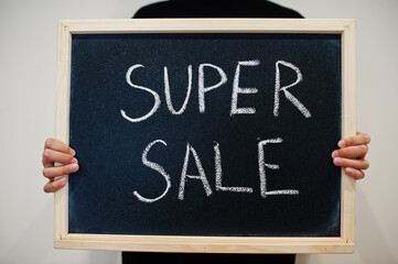 Super sale written on blackboard. Black friday concept. Boy hold board.