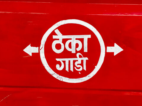 Text in Hindi on a red background on a transport vehicle meaning it is available on rent.