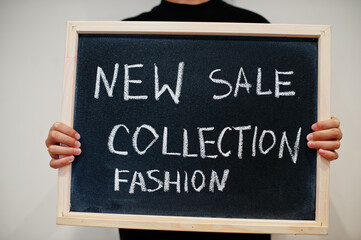 New collection sale fashion written on blackboard. Black friday concept. Boy hold board.