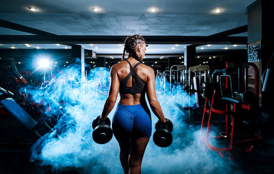 beautiful young black sportswoman in the gym. performs a workout.