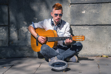 Male street musician singing and playing guitar on the streets of old European city.