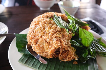 focus on traditional Thai slightly 
 fluffy Fried Omelet served on a banana leaf with Basil topping