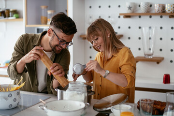 Young couple making delicious food at home. Loving couple enjoying in the kitchen.