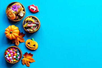 Halloween holiday background - gingerbread cookies, pumpkins and candy. Overhead