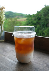 Focus on a cup of cold brew coffee on the wooden table with blurred background in a vertical frame