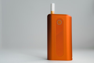 Heat-not-burn product with a stick on white background. Alternative smoking concept.