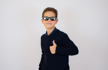 Confident cool boy with dark blue sweater and sunglasses, isolated on white background